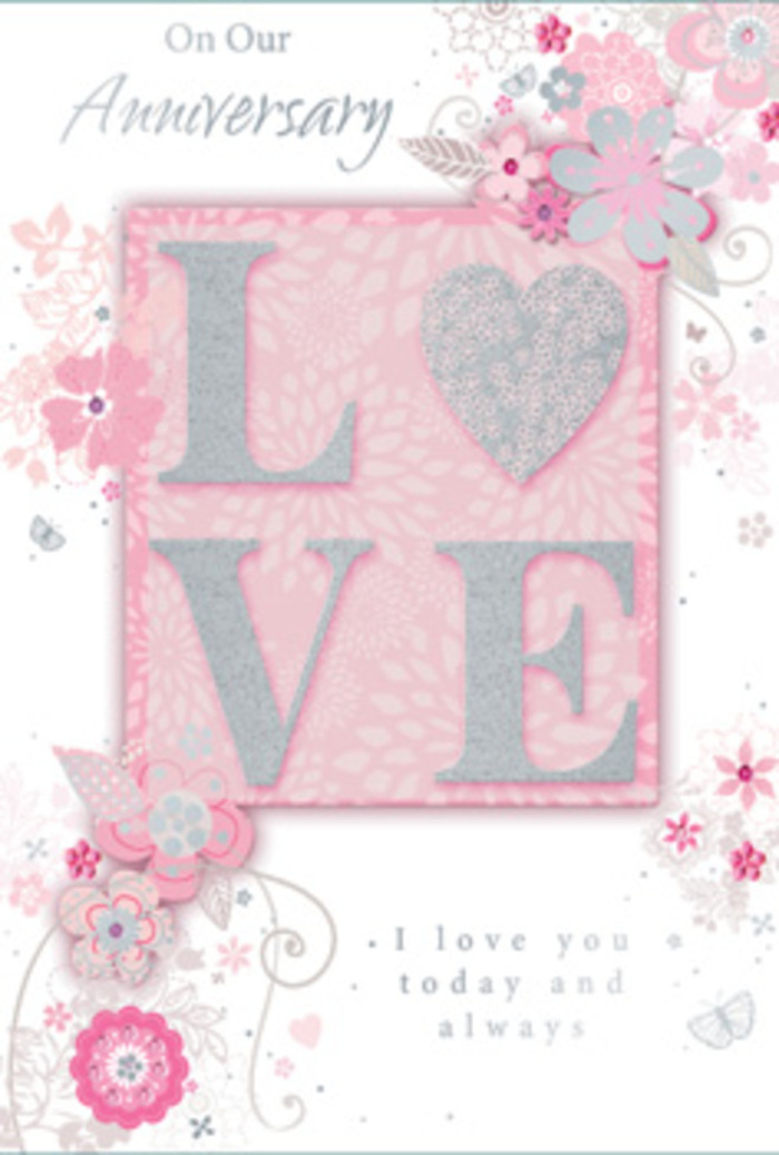 An ornate anniversary card is displayed, its composition evoking the gentle romance of a hand-crafted floral design, much like those arranged for couples around South Ruislip. The main motif is the word "LOVE," stretching confidently across the centre in raised letters coated with a soft glitter that shimmers in a controlled, elegant way. The glitter is pale, almost pearlescent, allowing the underlying blush tones of the letters to show through and creating a tactile contrast that suggests both smoothness and fine grain under the fingertips. This central word rests on a softly tinted pink background, its tone reminiscent of delicate rose petals laid in a single, even layer. From the edges of the lettering, clusters of stylised flowers and leaves radiate outward, as though the letters themselves were sprouting blossoms. The blooms are drawn with fine, confident lines and shaded in subtle gradients of blush, cream, and light grey, each petal and leaf carefully suggested rather than rigidly outlined. Some flowers resemble roses at mid-open, while others have simpler, rounded petals, all linked by slender stems and curling tendrils that mimic the natural drape of foliage in a bouquet prepared for delivery along Victoria Road or Long Drive. Interwoven with the florals are delicate scrolls and tiny dots, adding a lace-like intricacy. A graceful script message, marking the anniversary with warm, sincere words, appears nestled amidst the flowers, its lettering thin, looping, and perfectly in tune with the rest of the design. Overall, the card exudes a quiet, enduring romance, much like a cherished floral gift kept as a memento of a meaningful day in South Ruislip.